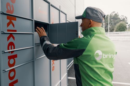 Bringbud legger pakke inn i en pakkeboks.