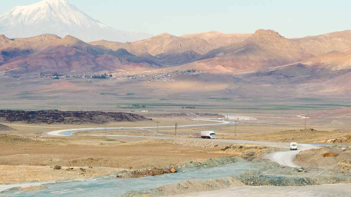 Landscape picture over Armenia, with trucks driving on the road.