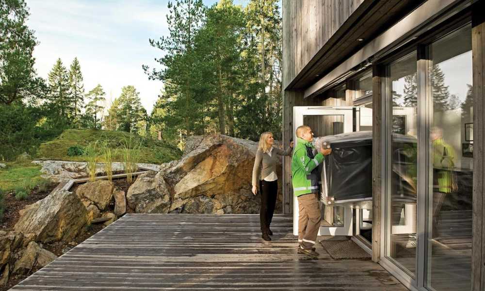 Two men carrying a sofa into a house