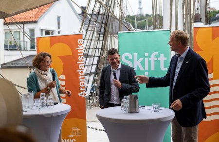 tre personer som presenterer på stand