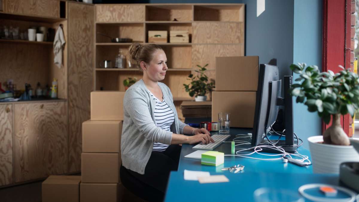 En kvinne som sitter på et kontor og jobber