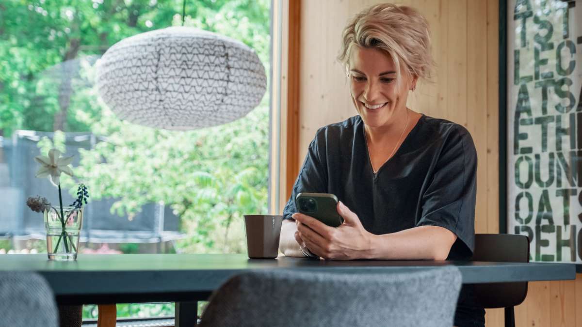 Kvinne smiler til telefonen