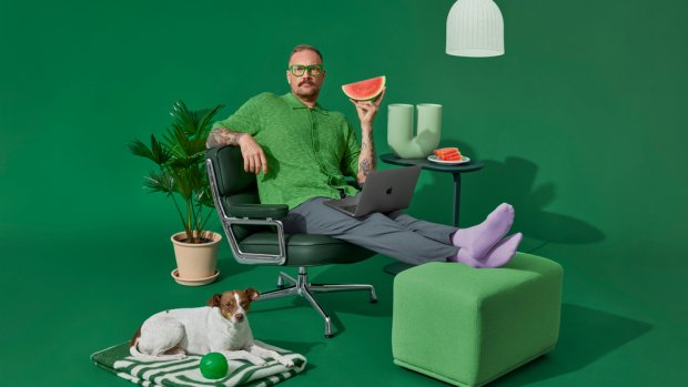 studiobilde mann sitter i stol med mac og vannmelon.