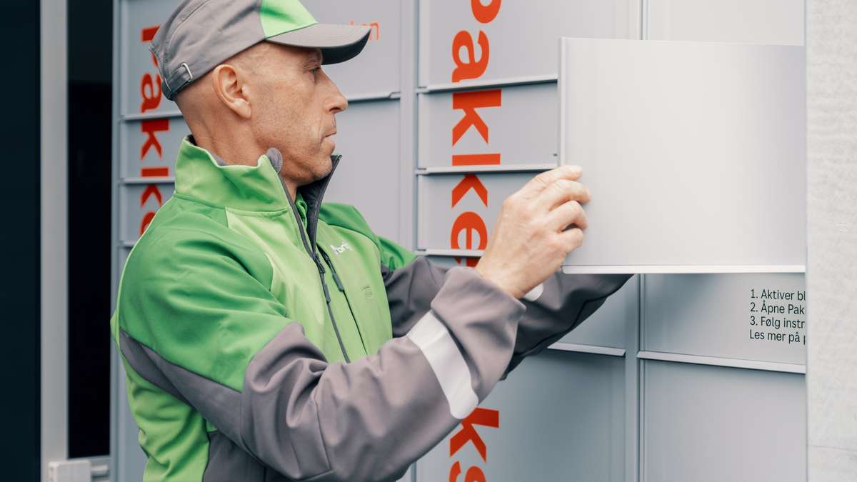 Bringbud legger pakke inn i en pakkeboks.