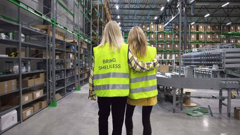 To jenter bakfra som går inne på et lager